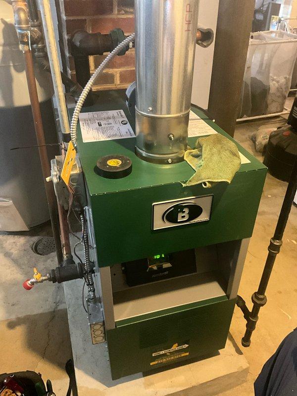 Performed routine maintenance service on 20+ year old MVP hot water boiler system. Checked temperature/pressure readings (approximately 120°F) and inspected exhaust ventilation. System is operational despite age with digital display reading 161.