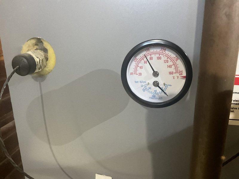 Performed routine maintenance service on 20+ year old MVP hot water boiler system. Checked temperature/pressure readings (approximately 120°F) and inspected exhaust ventilation. System is operational despite age with digital display reading 161.