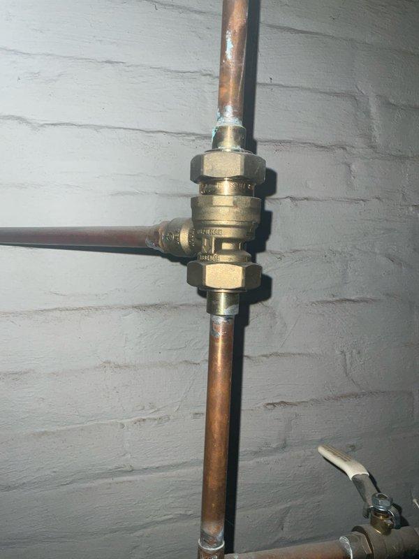 Performed scheduled tune-up and preventative maintenance on residential boiler system. Inspected plumbing connections, including brass T-junction valve and copper piping, noting minor oxidation but confirming proper function. Examined flue pipe and control systems, documenting all components in operational condition with no immediate service concerns.