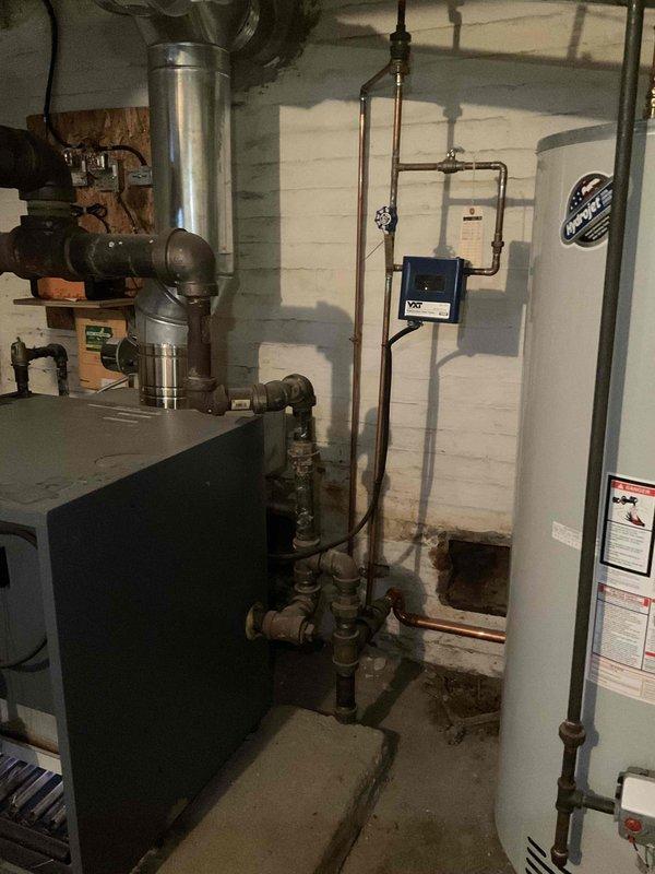 Performed scheduled tune-up and preventative maintenance on residential boiler system. Inspected plumbing connections, including brass T-junction valve and copper piping, noting minor oxidation but confirming proper function. Examined flue pipe and control systems, documenting all components in operational condition with no immediate service concerns.