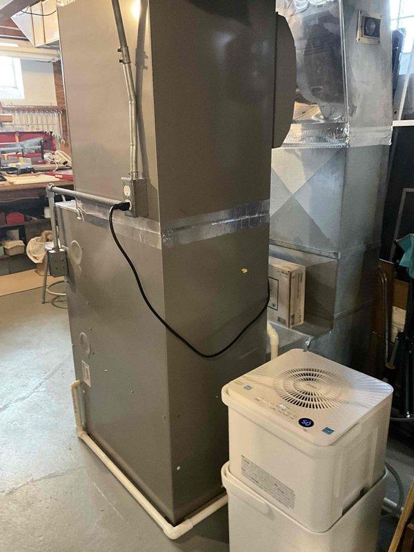 Performed inspection on 20-year-old furnace in dual fuel heat pump system. Evaluated existing Carrier unit and associated ductwork, noting connection points and ventilation components. System includes supplementary air purifier/humidifier unit. Assessment completed for potential replacement options.