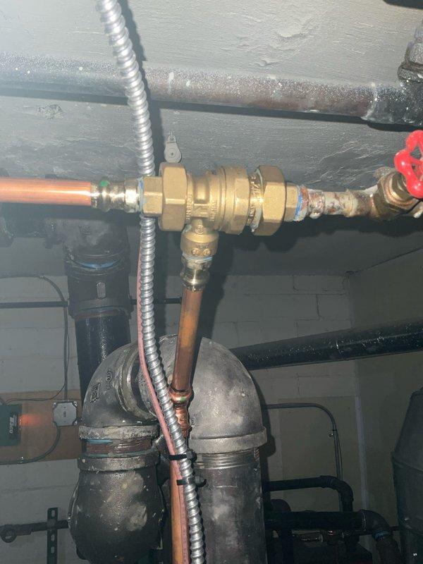 Performed annual maintenance inspection on 1-year-old boiler system. Examined backflow preventer, pressure regulator valve, and all copper pipe connections for proper function and signs of leakage. Inspected boiler unit, flue pipe, and PVC venting system, confirming all components are in good working order with no visible issues.