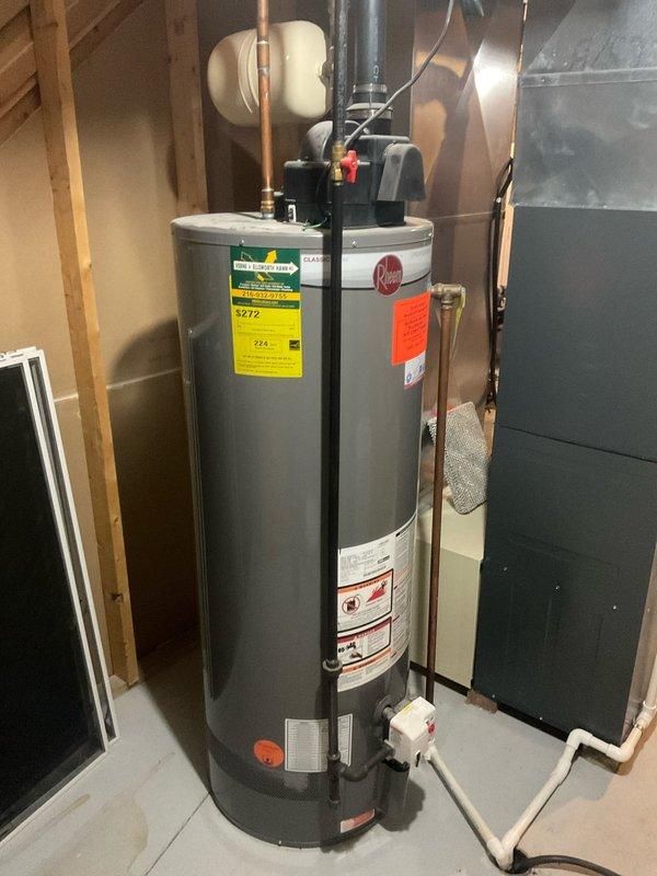 Conducted service call to assess customer's water heater replacement needs. Inspected existing Rheem tank water heater located in basement utility room, noting connections to copper supply lines, PVC drainage, and black vent piping. Also examined expansion tank mounted on HVAC equipment. Provided customer with replacement options and installation estimate as requested.