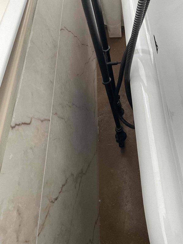 Conducted site assessment for installation of supplemental baseboard heating in bathroom with existing geothermal system. Evaluated current plumbing configuration and available space between bathtub and wall for proper placement. Recommended appropriate baseboard unit compatible with geothermal setup to provide additional heat source as requested.