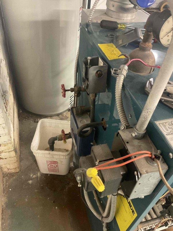 Performed annual heating maintenance on a residential boiler system. Inspected and serviced the burner assembly, checked all connections and valves for proper operation, and verified venting system integrity. No significant issues found in the teal-colored boiler unit or associated components including expansion tank and circulation system.