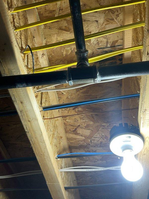 Performed scheduled assessment of tankless water heater system to verify proper operation. Inspected all connections including hot/cold water lines, pressure relief valve, and gas supply line. Examined PEX plumbing runs and drainage pipes in ceiling area; confirmed all components functioning correctly with no leaks or operational issues detected.