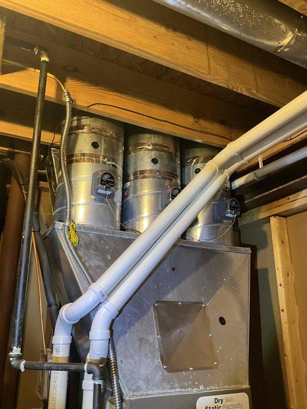 Performed second opinion inspection on Luxaire furnace system with suspected heat exchanger failure. Visual examination confirmed heat exchanger deterioration requiring full replacement. System is currently installed in basement utility area with existing PVC ventilation and drainage components. Noted water staining beneath unit, suggesting possible condensate drainage issues that would need addressing during replacement.