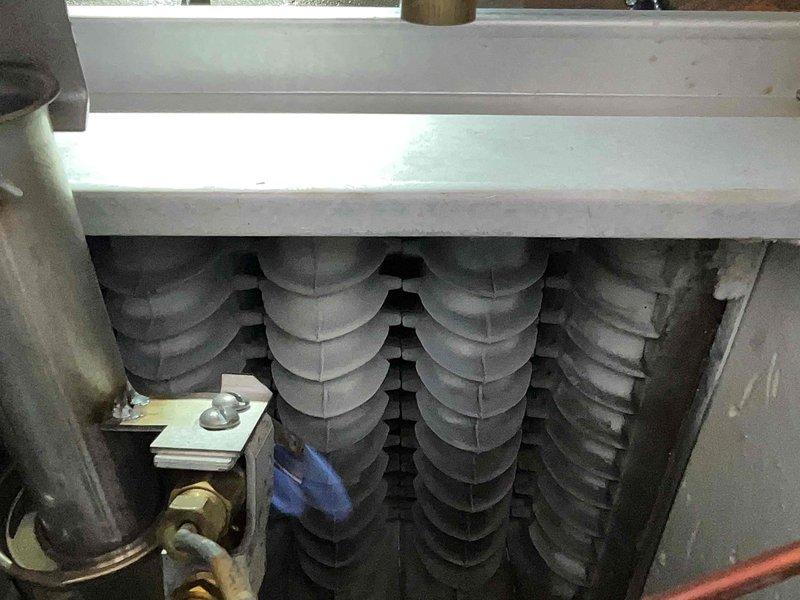 Performed scheduled maintenance on 23-year-old steam boiler. Conducted combustion analysis with readings showing optimal oxygen levels (21.0%), zero carbon monoxide (0 PPM), and normal operating temperature (76.7°F). Inspected heat exchanger components and verified proper condition of internal fins and piping.