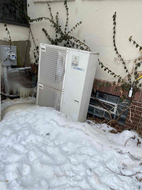 Responded to service call for non-functioning 15-year-old Mitsubishi City Multi system. Inspection revealed outdoor unit heavily obstructed by snow accumulation with significant ice formation on connections and piping. System was unable to operate efficiently due to restricted airflow and frozen condensate drainage. Cleared snow/ice buildup, verified electrical connections, and restored proper operation of the unit. Also noted secondary issue with boiler system not adequately heating master suite area.