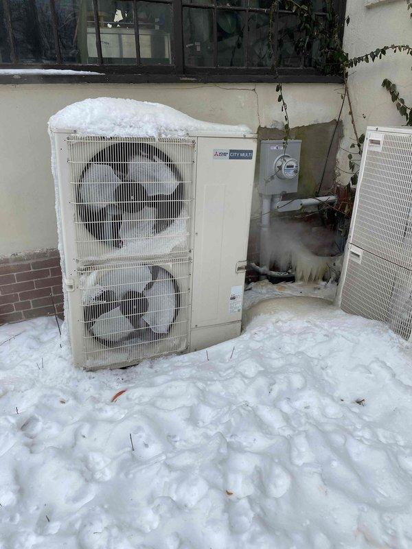 Responded to service call for non-functioning 15-year-old Mitsubishi City Multi system. Inspection revealed outdoor unit heavily obstructed by snow accumulation with significant ice formation on connections and piping. System was unable to operate efficiently due to restricted airflow and frozen condensate drainage. Cleared snow/ice buildup, verified electrical connections, and restored proper operation of the unit. Also noted secondary issue with boiler system not adequately heating master suite area.