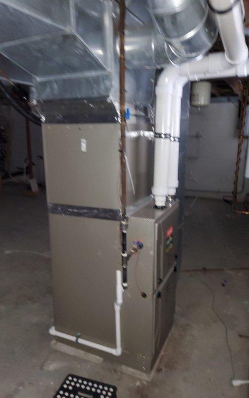 Performed scheduled maintenance on residential furnace system located in utility area. Inspected gas furnace unit with PVC venting system and connected ductwork for proper operation. Verified all components functioning correctly with no issues identified during the service appointment.