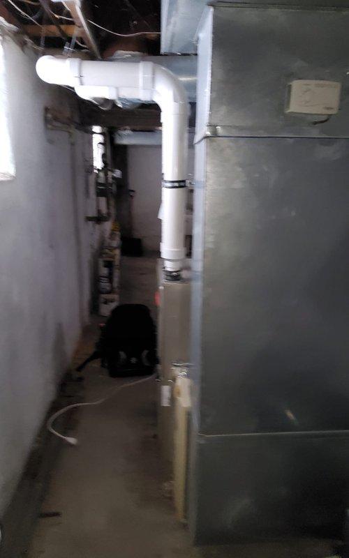 Performed scheduled maintenance on residential furnace system located in utility area. Inspected gas furnace unit with PVC venting system and connected ductwork for proper operation. Verified all components functioning correctly with no issues identified during the service appointment.