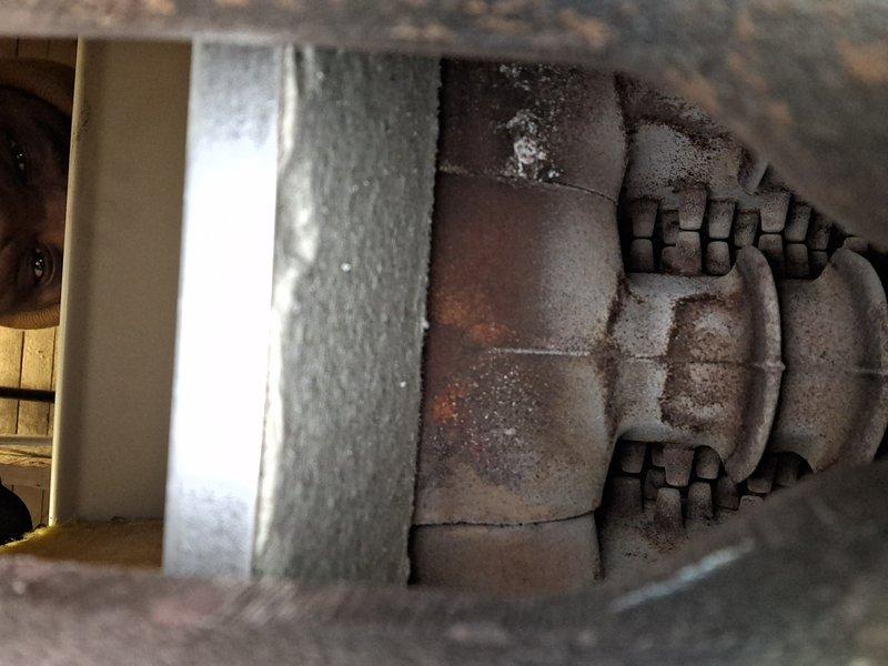 Performed routine maintenance service on 20+ year old natural gas steam boiler. Inspected heat exchanger showing normal aging with some rust and soot accumulation. Cleaned accessible components and verified proper operation of system.