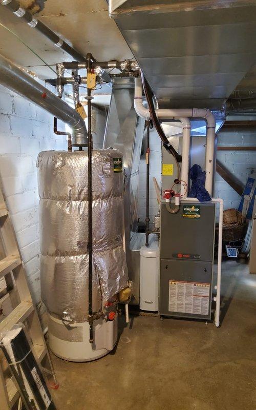 Performed scheduled furnace tune-up on residential heating system. Inspected gas burners and confirmed proper blue flame combustion indicating efficient operation. Examined water heater and associated piping connections, with all components functioning normally.