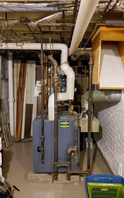 Conducted scheduled preventive maintenance on residential steam boiler system. Inspected pressure gauge readings, checked all copper lines and connections for leaks, and verified proper operation of expansion vessel. Placed collection bucket under minor condensate drip point for temporary containment while servicing the system.