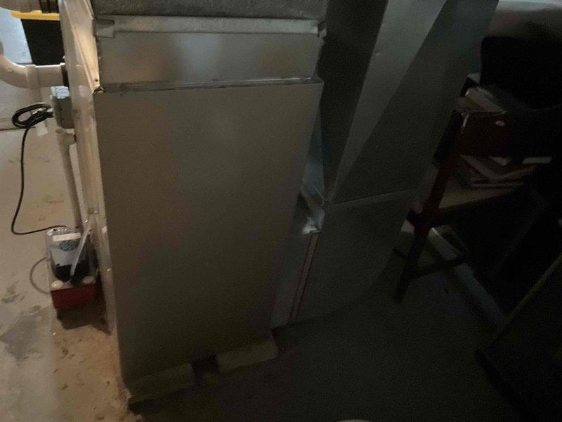 Conducted comprehensive evaluation of existing HVAC system for potential replacement. System located in basement utility area shows significant age deterioration with estimated 2/10 remaining service life. Documented current setup including furnace unit, ductwork configuration, and ventilation components to prepare accurate replacement proposal for client Derek.