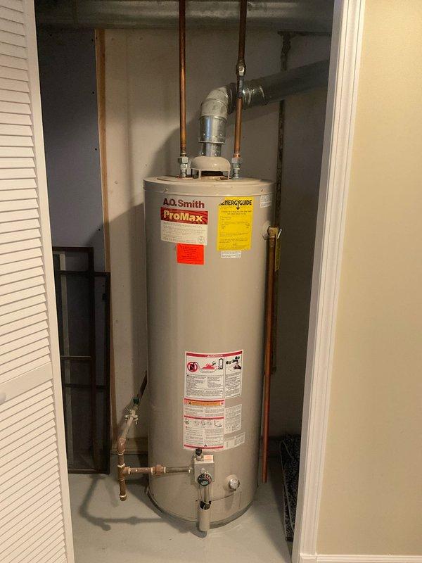 Performed inspection of existing A.O. Smith ProMax water heater installation. System features copper supply lines, metal vent pipe with 90-degree elbow, and standard shut-off valves. Noted proper installation with no visible leaks or deterioration in tank or plumbing components. Provided estimate for new hot water tank replacement as requested by customer.