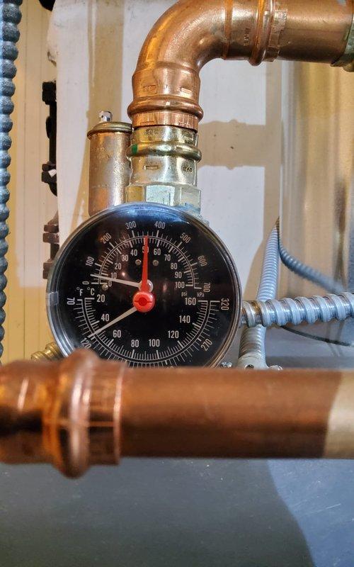 Performed scheduled maintenance on hydronic boiler system that had been previously rescheduled. Inspected ventilation components which showed significant dust accumulation requiring cleaning. Checked system pressure gauge which was operating within normal parameters on the copper supply/return piping.