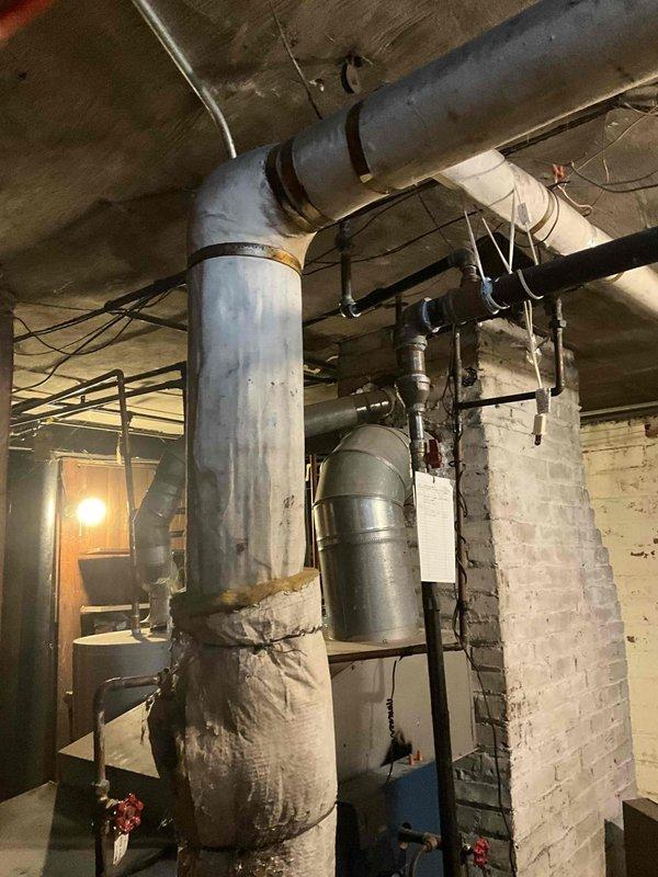 Conducted steam boiler replacement estimate for aged system with deteriorating pipe insulation. Inspection revealed multiple worn components in the mechanical area, including compromised insulation on main vertical and horizontal distribution pipes. Recommendation for complete replacement of existing 2/12 steam boiler with new unit.