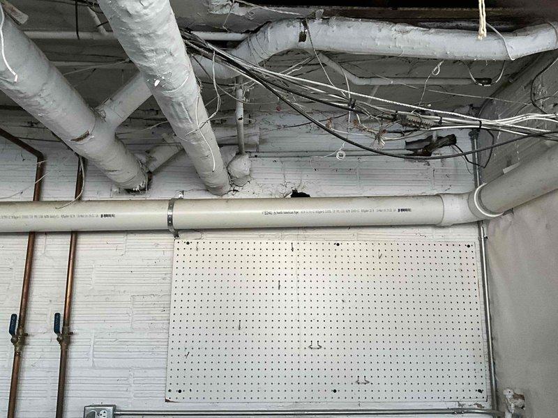 Conducted inspection of mini split system and boiler installation to address improper venting configuration. Identified that boiler exhaust is currently venting directly onto mini split units, causing them to ice over. Documented existing utility infrastructure in basement mechanical area to prepare comprehensive estimate for proper ventilation system modification.