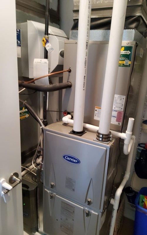 Responded to service call for non-functioning thermostat. Inspected Carrier furnace system with PVC venting in utility area. Found damaged connection at thermostat wiring which was causing communication failure; repaired connection and tested system through complete heating cycle to confirm proper operation.