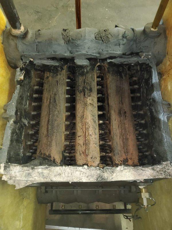Responded to no heat call on 17-year-old boiler under warranty coverage. Inspection revealed heavily fouled heat exchanger with significant soot accumulation and mineral deposits, indicating prolonged deterioration. Documented condition with photos for warranty claim processing.