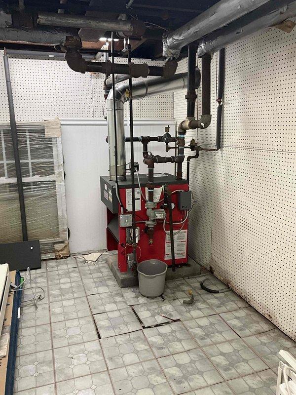 Performed diagnostic assessment on non-functional boiler system estimated to be 3-5 years old. Inspection revealed electrical connectivity issues at the circuit breaker panel and deteriorating condition of the heating unit. Documentation included photographic evidence of the electrical panel configuration and the existing boiler installation with associated piping network for comprehensive evaluation and replacement planning.