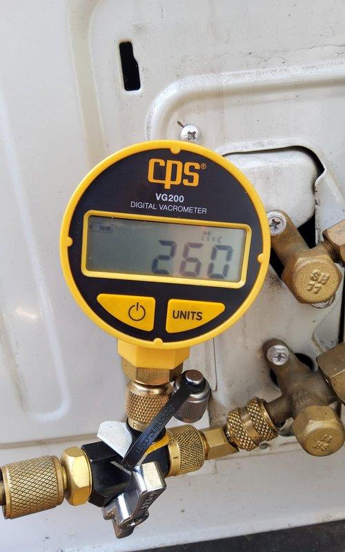 Responded to service call for heat pump refrigerant leak. Performed diagnostic testing using CPS VG200 Digital Vacuometer, achieving 26.0 in Hg vacuum level, confirming system integrity after repairs. Successfully sealed leak and recharged system to manufacturer specifications, restoring proper operation of the outdoor condenser unit.
