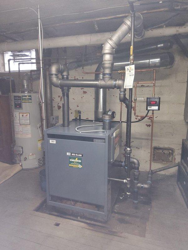 Successfully replaced an aging Weil-McLain steam boiler system in basement mechanical room, including installation of new boiler feed pump (BFP), water feeder, and thermostat. System was properly connected to existing piping infrastructure with all connections tested to ensure proper operation and efficiency of the new heating equipment.