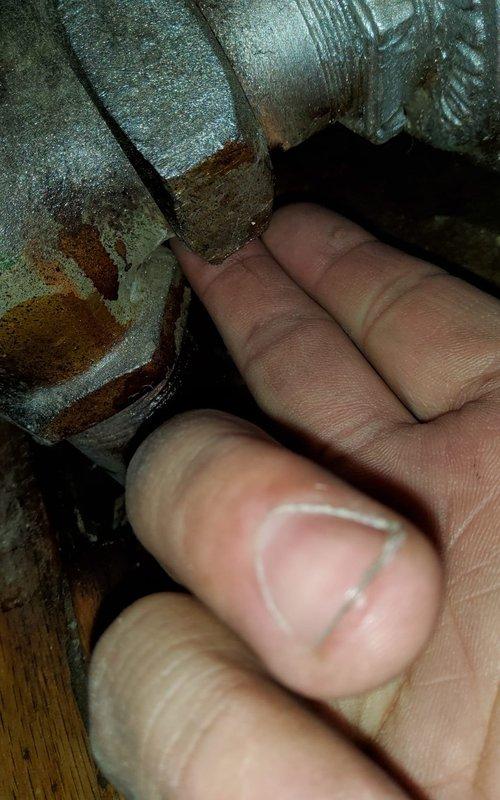 Responded to service call for reported water leakage from radiator system. Upon inspection, identified significant corrosion at pipe connections of cast iron radiator located in dining room. Observed water damage to wooden flooring surrounding radiator pipe penetration and confirmed related ceiling collapse in basement storage area directly below. Documented condition with photographs showing deteriorated fittings and water staining.