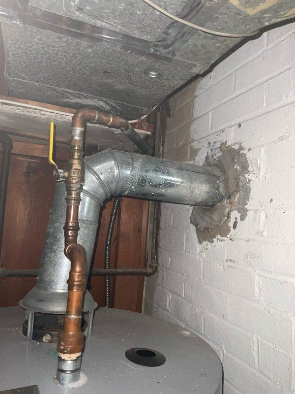 Replaced failing water heater with new Lochinvar unit in 50-year-old residence. Installed new copper supply lines, properly connected flue pipe to existing wall penetration, and verified all connections for leaks. System is now operational with proper venting and compliant installation.