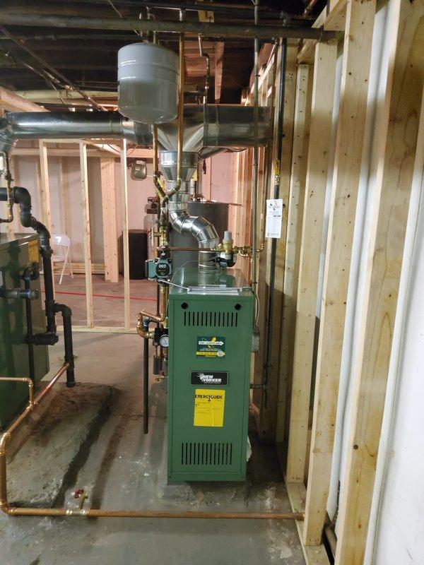 Completed installation of dual boiler system, replacing existing units with new steam boiler for main house (including new backflow preventer and auto feeder) and new hot water boiler with thermostat, backflow/PRV combo, pump and expansion tank. Consolidated ventilation system by replacing flue pipe setup completely, connecting both boilers and hot water tank into a single common vent with appropriate tees, resulting in one larger vent pipe entering the chimney rather than the previous three-pipe configuration.