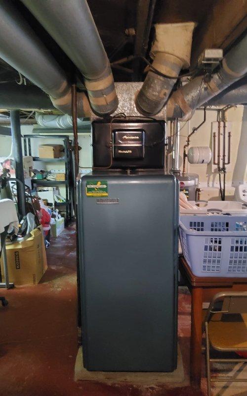 Performed routine maintenance on Heatmaker furnace system located in basement utility area. Conducted comprehensive inspection of belt-driven unit, checking flame pattern and internal components for proper operation. System is functioning correctly with no immediate issues identified; customer advised about maintenance plan renewal options.