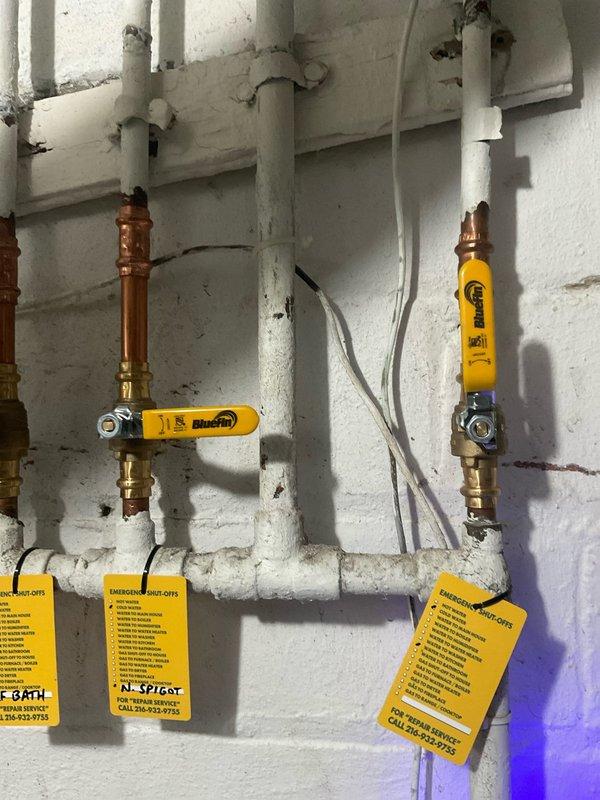 Completed installation of new gas line emergency shut-off valves for hot water heater, replacing deteriorated components. Identified and addressed corrosion at PVC pipe connection point where visible mineral buildup indicated an active leak. Installed Gastite-branded yellow handle valves on horizontal pipe sections with appropriate emergency shut-off tags for future reference.