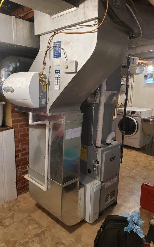 Performed standard furnace tune-up on residential system located in basement. Inspected and replaced dirty air filter. Addressed squeaking noise from furnace by lubricating blower motor bearings and checking belt tension. System now operating within normal parameters with noise issue resolved.
