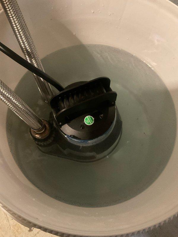 Performed maintenance service on Elvernay tankless water heater in 37-year-old residential property. Inspected unit mounted on concrete block wall, checked all copper and PVC pipe connections, and examined the expansion tank for proper operation. Found and cleaned sump pump basin with accumulated sediment affecting water discharge efficiency, replacing the pump's discharge line to restore proper functionality.