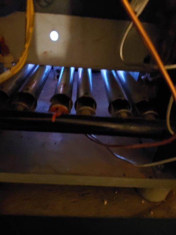 Performed scheduled heating tune-up on residential furnace system. Inspected burner assembly operation, confirming proper flame characteristics with consistent blue flames across all tubes. Noted dust accumulation on heat exchanger fins requiring cleaning to optimize system efficiency and heating performance.