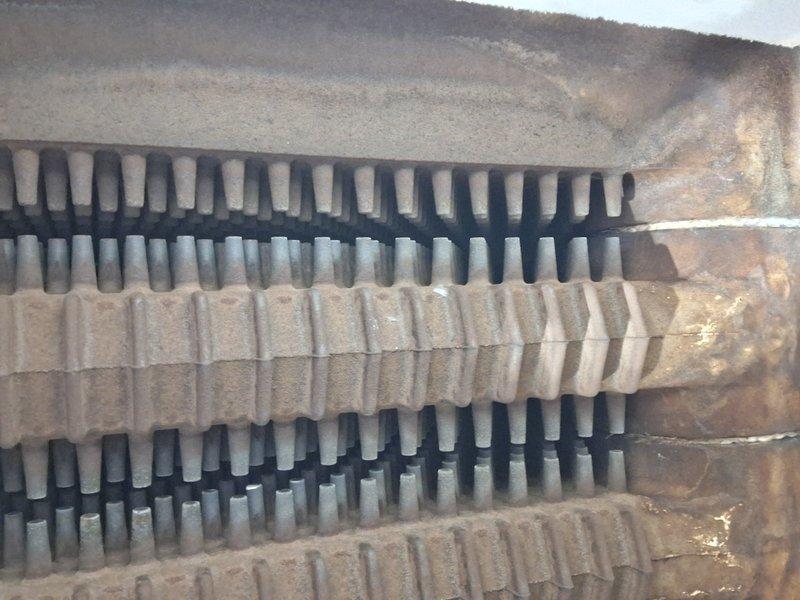 Performed scheduled boiler tune-up service, inspecting heat exchanger components which showed signs of oxidation and dust accumulation on the metal fins. Observed multiple rows of heat transfer elements with some corrosion present but still functional. Service was rescheduled from a previous appointment.