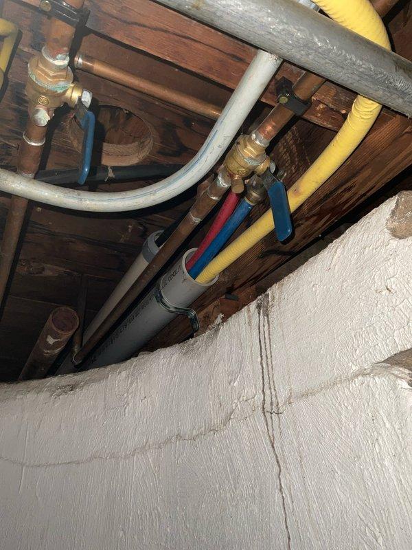 Replaced failed cold water supply line to kitchen. Installed new copper piping with brass fittings and blue-handled shutoff valves along basement joists. System was pressure tested and confirmed operational with no leaks.