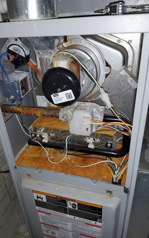 Responded to no-heat service call for dual 15-year-old furnace system in a two-family residence. Diagnostic inspection revealed significant rust/oxidation on the furnace base indicating moisture exposure and age-related deterioration. Successfully performed maintenance using specialized tools to restore heating function to both units, addressing blower motor issues and ensuring proper electrical connections throughout the system.