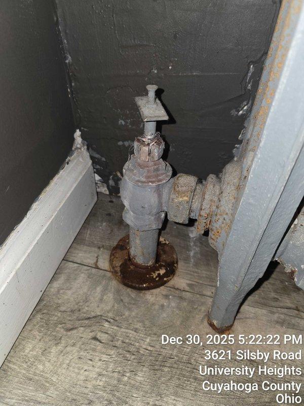 Responded to service call for broken air vent and valve repair. Inspection revealed a cast iron radiator with significant water damage to surrounding hardwood flooring, and a heavily corroded water shutoff valve requiring replacement. Documented damage with photos for customer records.
