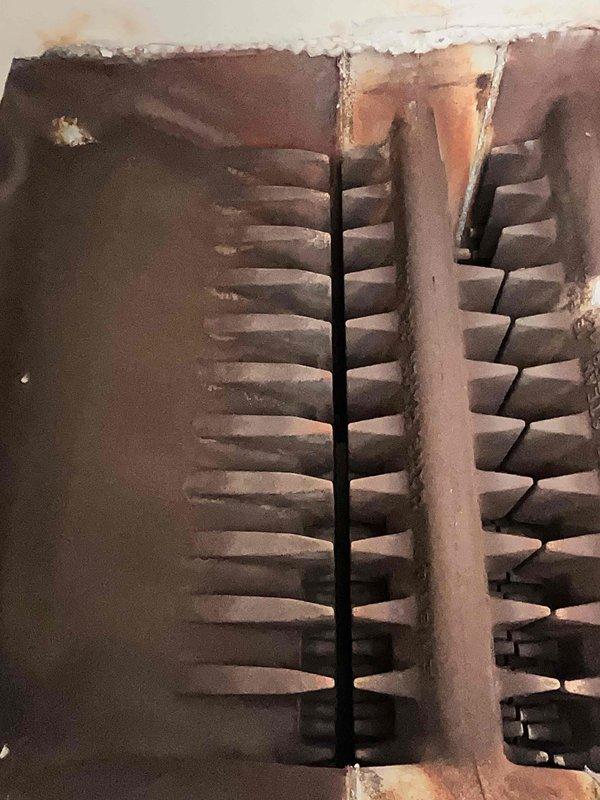 Performed routine maintenance on 7-year-old steam boiler system. Inspected heat exchanger fins for proper operation, noting some age-related discoloration but no significant deterioration. System is functioning within normal parameters after service completion.