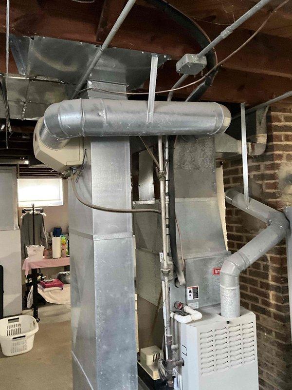 Conducted comprehensive evaluation of 24-year-old furnace and AC system in basement utility area. Inspection revealed aging equipment with standard galvanized ductwork configuration running through exposed joists. Replacement estimate provided for complete HVAC system upgrade to address equipment age and improve efficiency.