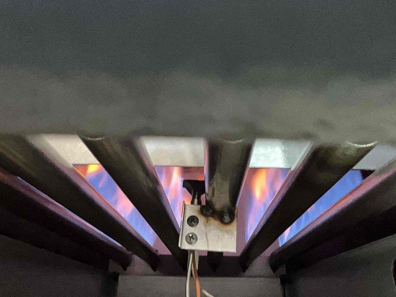 Performed scheduled heating tune-up on 4-year-old MVP system, which had been rescheduled twice. Inspected heat exchanger showing signs of corrosion and moisture accumulation in collection pan. Verified proper burner operation with strong blue flames at base transitioning to orange tips, indicating normal combustion.