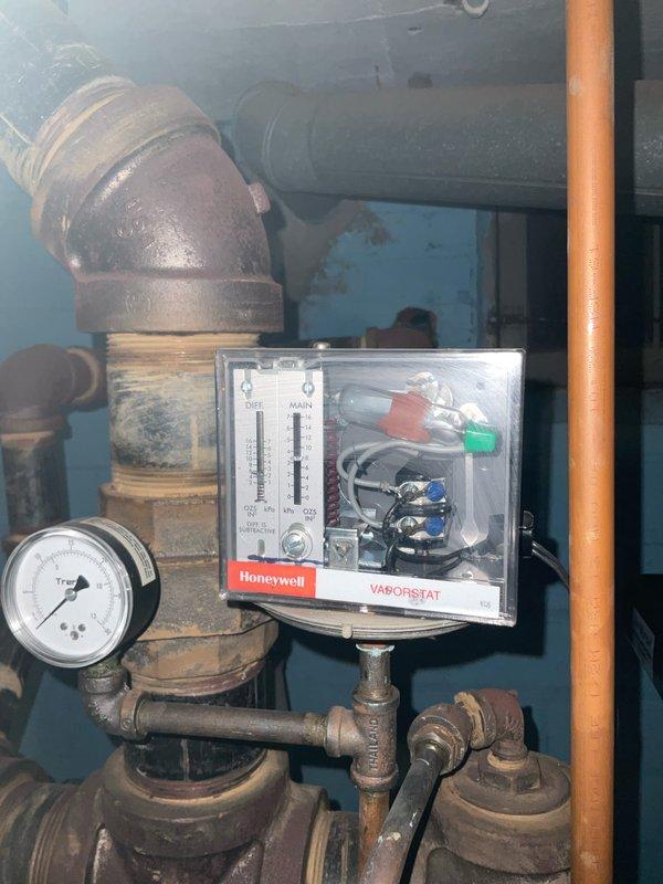 Completed annual maintenance inspection on 19-year-old steam boiler system. Examined and tested the Honeywell Vaporstat control device, pressure gauges, and associated piping components. System showing expected age-related wear with minor corrosion at pipe joints, but all control mechanisms and pressure systems are functioning within normal operating parameters.