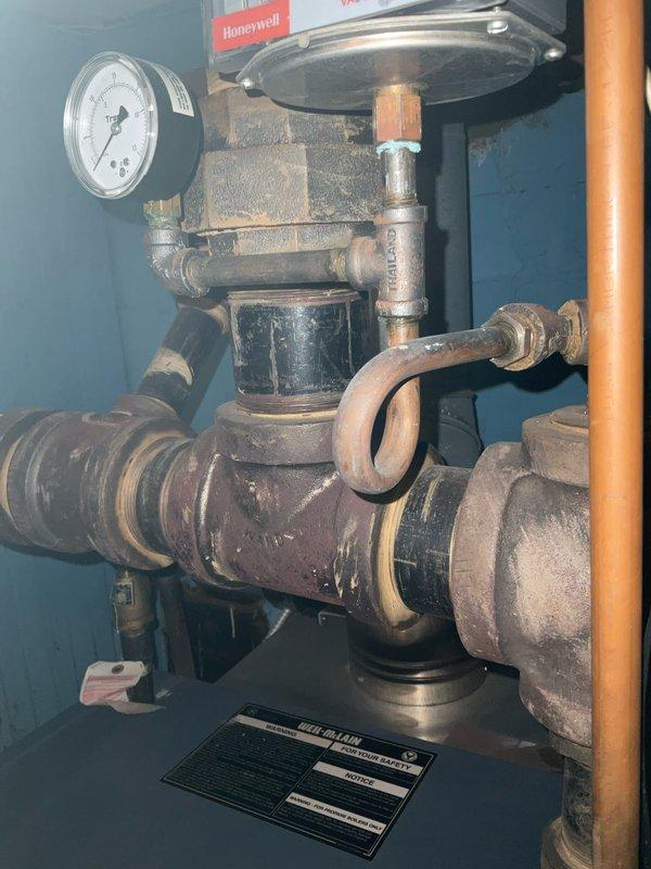 Completed annual maintenance inspection on 19-year-old steam boiler system. Examined and tested the Honeywell Vaporstat control device, pressure gauges, and associated piping components. System showing expected age-related wear with minor corrosion at pipe joints, but all control mechanisms and pressure systems are functioning within normal operating parameters.