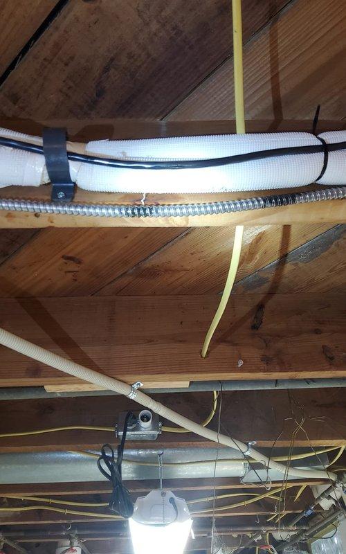 Performed scheduled preventative maintenance on mini-split heating system. Inspected copper refrigerant lines and electrical connections, noting minor condensation on copper line. Verified proper installation of insulated refrigerant line secured to joists with appropriate fasteners alongside electrical conduit.
