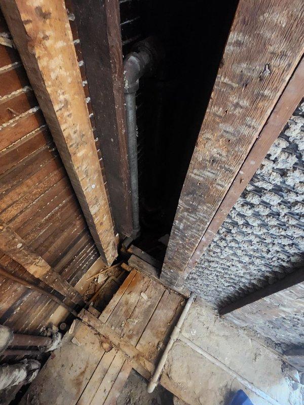 Responded to service call for clogged drain. Conducted thorough inspection using scope camera on exposed shower drain pipe where shower had been previously demolished. Visual inspection of wall cavity revealed possible structural issues affecting drainage system, with photos documenting the condition of aged wooden supports and vertical plumbing infrastructure.