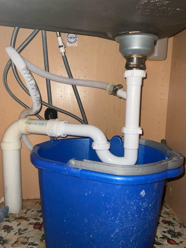 Responded to a service call for a sink leak in a century-old home. Upon inspection, discovered mineral buildup in the drain assembly causing leakage from the metal P-trap. Removed the corroded metal trap, installed new PVC P-trap and drain assembly components, and verified proper drainage with no leaks.