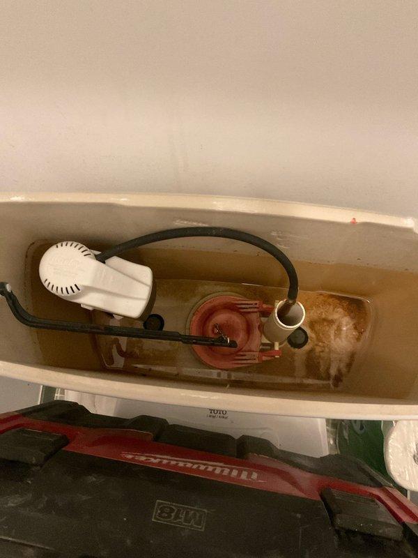 Diagnosed and repaired leaking TOTO toilet in 43-year-old residential bathroom by replacing deteriorated flapper valve and addressing mineral buildup in tank. Inspected supply line connections and floor mounting to ensure proper installation, eliminating leak and restoring proper flush functionality.